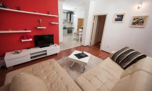 a living room with a couch and a tv at Žnjan Beach Apartments in Split