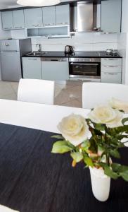 a kitchen with a white table with flowers on it at Žnjan Beach Apartments in Split