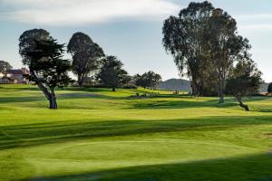 un parcours de golf verdoyant avec des arbres au premier plan dans l'établissement Sea Pines Golf Resort, à Los Osos