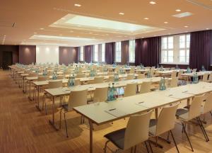 a large room filled with tables and chairs at HYPERION Hotel Dresden Am Schloss in Dresden