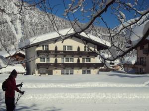 a man standing in the snow in front of a building at Bergheim in Pertisau