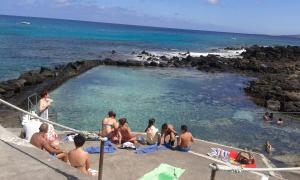 a group of people sitting in a swimming pool on the beach at Casa Flor in Punta Mujeres