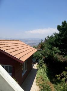 Casa con techo rojo y vistas en Cabin In The View, en Hararit
