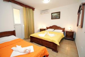 1 dormitorio con 2 camas y toallas. en Apartmani More, en Sveti Stefan