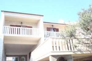 a white house with a white balcony on it at Villa Mila in Bol