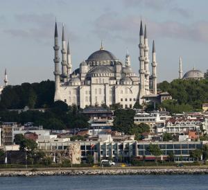 a large white mosque with two domes on top of a city at Kalyon Hotel Istanbul in Istanbul