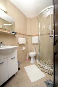 a bathroom with a shower and a toilet and a sink at Apartmani More in Sveti Stefan