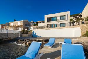 a group of blue chairs and a house at Villa Krasici in Tivat