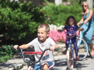 a young boy riding a bike next to a girl at The Abbey Resort in Lake Geneva