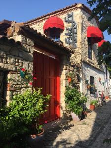 un edificio con una puerta roja y un cartel en él en Alacati Eski Ev Hotel, en Alacati