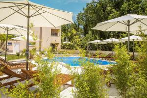 - une piscine bordée de chaises longues et de parasols dans l'établissement Residence Mediterraneo, à Baška