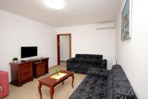 a living room with a couch and a tv at Apartmani More in Sveti Stefan