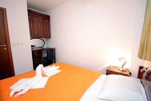 a bedroom with a bed with white gloves on it at Apartmani More in Sveti Stefan