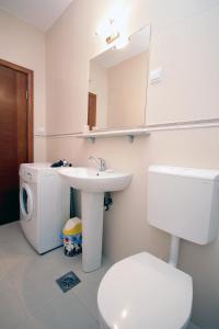 a bathroom with a sink and a toilet and a mirror at Apartmani More in Sveti Stefan