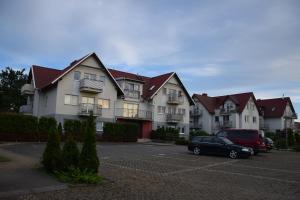 a large house with a car parked in a parking lot at Apartament Nad Dzika Plaza in Puck