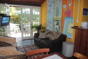 a living room with a couch and a tv at Pousada Casa de Praia in Florianópolis