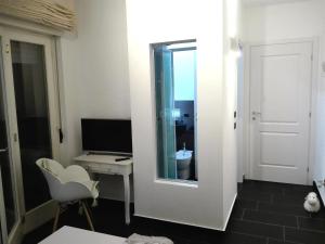 a room with a mirror and a desk and a television at B&B Stazione Latina in Sermoneta