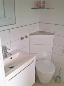 Baño blanco con aseo y lavamanos en Studio Muenster City en Münster