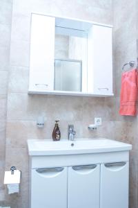 uma casa de banho com um lavatório branco e um espelho. em Luxury apartment Promenade Expo em Astana