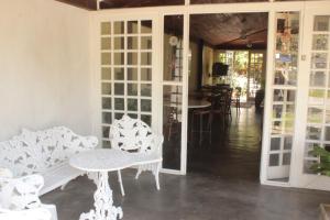 a room with white furniture and a table and chairs at Pousada Casa de Praia in Florianópolis