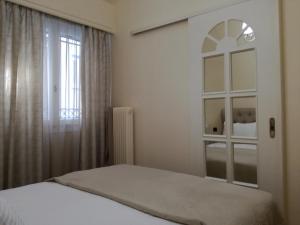 Schlafzimmer mit einem Bett und einem Fenster in der Unterkunft Thiseio Home in Athen