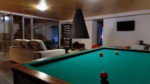 a living room with a pool table and chairs at Casal de Palácios in Bragança
