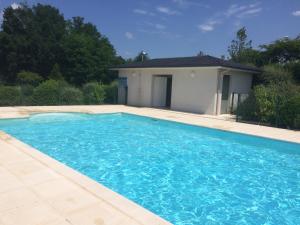 a large blue swimming pool in front of a house at Résidence CAP HORIZON in Brive-la-Gaillarde