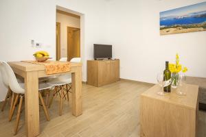 a living room with a dining room table and a television at Residence Mediterraneo II in Baška