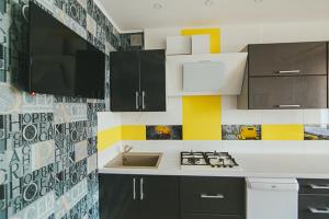 uma cozinha com armários a preto e branco e um lavatório em VIP apartmen em Sumy