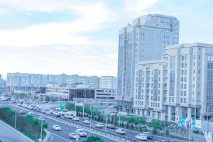 a city with cars on a highway with tall buildings at Luxury apartment Promenade Expo in Astana