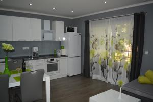 a kitchen and living room with white cabinets and a table at Apartment D & N in Kaštela