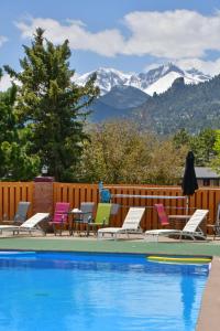 a pool with chairs and mountains in the background at Murphy's Resort in Estes Park