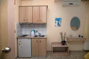 a small kitchen with a sink and a refrigerator at Arion Hotel in Skala Potamias