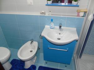 a blue bathroom with a sink and a toilet at Casa Valente in Manfredonia