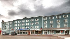 a large blue building with cars parked in front of it at Best Western Gold Rush Inn in Whitehorse