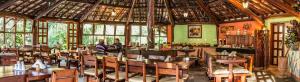 a restaurant with wooden tables and chairs and windows at Hotel Parque Das Primaveras in Caldas Novas