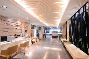 a lobby of a restaurant with a bar and chairs at Kiwi Express Hotel - Kaohsiung Station in Kaohsiung