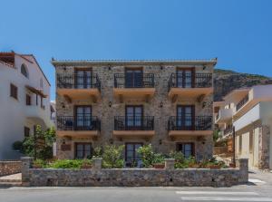 an apartment building with balconies on the side of it at Petrino Guesthouse in Monemvasia