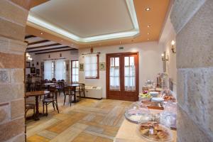 a kitchen and dining room with tables and chairs at Petrino Guesthouse in Monemvasia