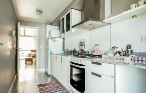 Una cocina con gabinetes blancos y un horno de estufa. en 457 Gascon, en Mar del Plata