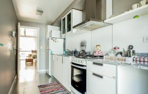 a kitchen with white cabinets and a stove top oven at 457 Gascon in Mar del Plata