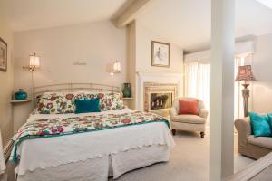 1 dormitorio con 1 cama grande y 1 silla en Captain Farris House en South Yarmouth