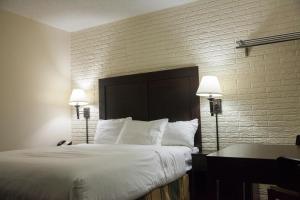 a hotel room with a bed and two lamps at Inns of Virginia Arlington in Arlington