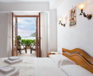 a bedroom with a bed and a view of the ocean at Petrino Guesthouse in Monemvasia
