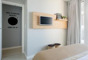 Un dormitorio con una cama y un televisor en una pared. en 457 Gascon, en Mar del Plata