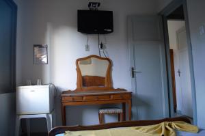 a room with a mirror and a dresser and a television at Hotel Sorrento in Belo Horizonte