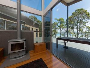 a living room with a fireplace in a house at Cloudy Bay Lagoon Estate in South Bruny