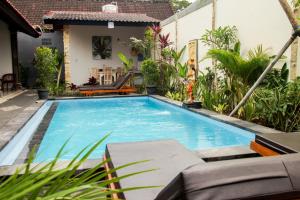 a swimming pool in the yard of a house at Nyoman Guesthouse Canggu in Canggu
