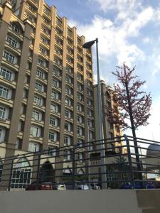 a large building with cars parked in front of it at Apartment Wakaf Che yeh in Kota Bharu