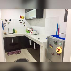 eine kleine Küche mit einer Theke und einem Kühlschrank in der Unterkunft Apartment Wakaf Che yeh in Kota Bharu
